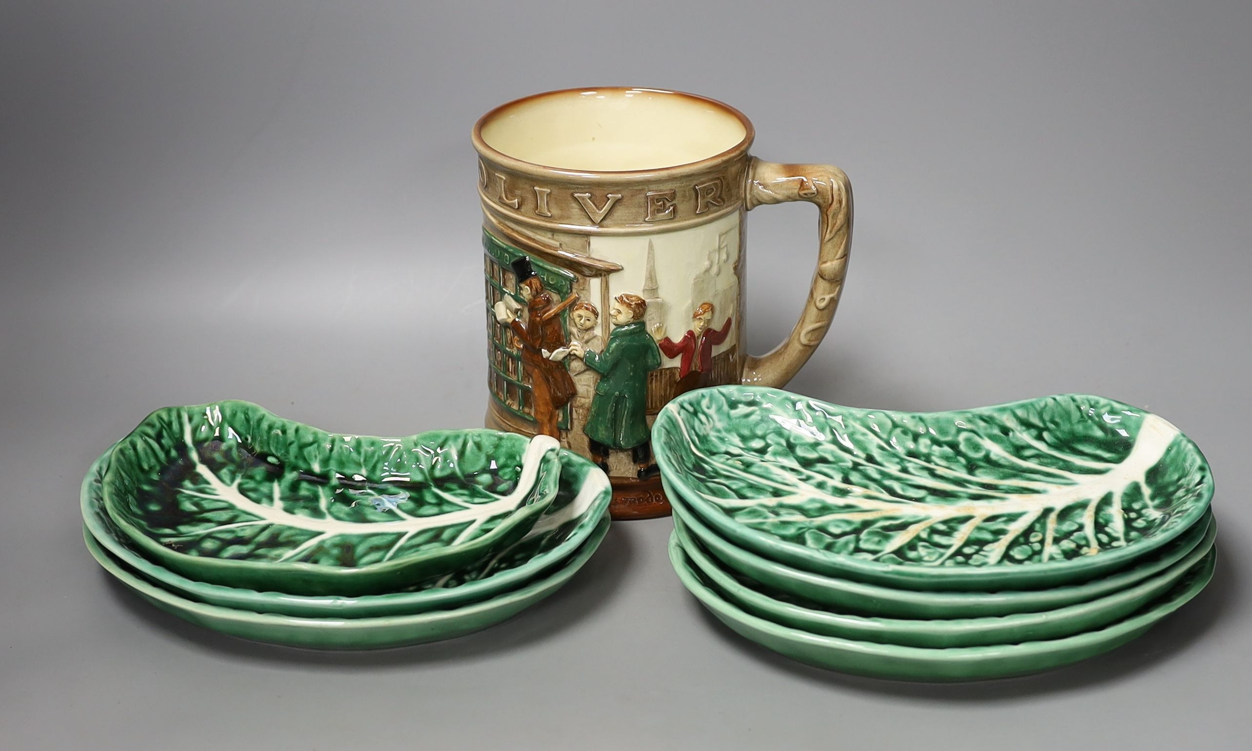 A Doulton Oliver Twist mug and eight Portuguese leaf dishes